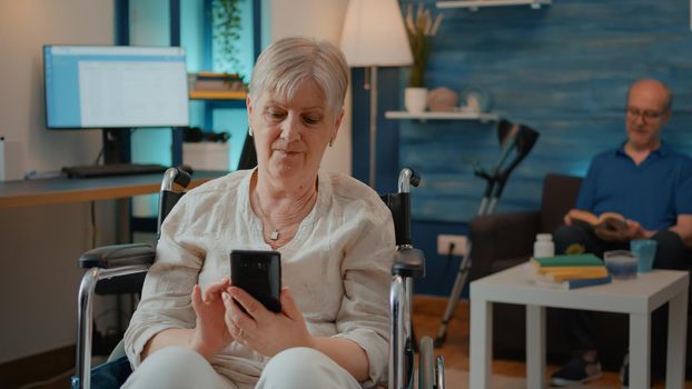 Senior adult with disability browsing internet on smartphone