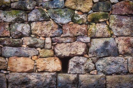 Old rustic stone wall with varied colors and sizes and textures