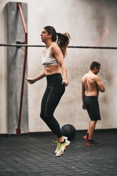 You are your only limit. Shot of a young woman skipping rope in a gym.