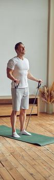 Strong man using resistance bands at home