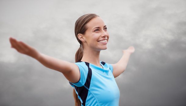 Ah, feeling good and enjoying the crisp air. Shot of a young woman training outdoors with her arms outstretched.