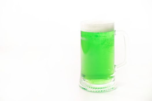 A pint of green beer for st patrick's day on a white background. Traditional Irish drink for a holiday. Copy space