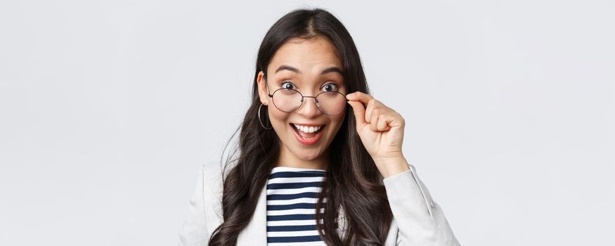 Business, finance and employment, female successful entrepreneurs concept. Excited happy asian office worker take-off glasses and smiling astonished as receive awesome deal