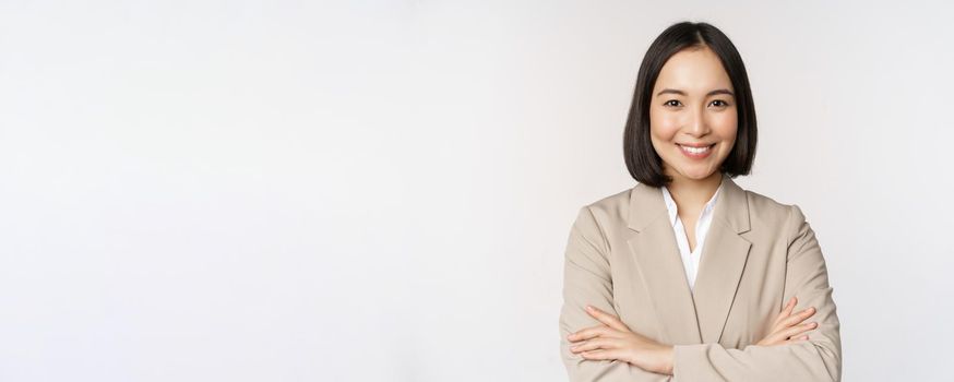 Confident female entrepreneur, asian business woman standing in power pose, professional business person, cross arms on chest, standing over white background.