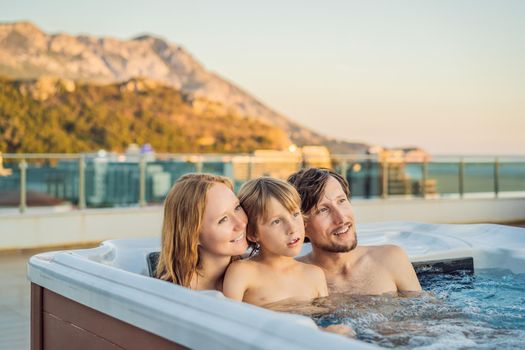 Portrait of young carefree happy smiling happy family relaxing at hot tub during enjoying happy traveling moment vacation. Life against the background of green big mountains