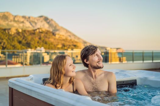 Portrait of young carefree happy smiling couple relaxing at hot tub during enjoying happy traveling moment vacation life against the background of green big mountains