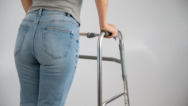 A woman is walking with a walker on a white background