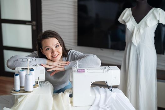 Young caucasian woman sews at home