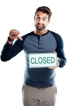 Sorry, you missed out. Studio portrait of a handsome young man holding a closed sign against a white background.