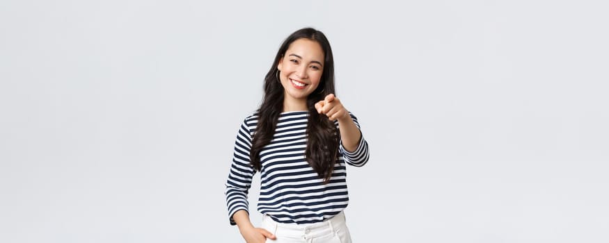 Lifestyle, beauty and fashion, people emotions concept. Happy cheerful asian girl praising you, picking person, found excellent employee for job position, pointing camera and smiling.