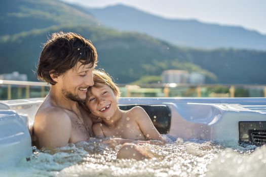 Portrait of young carefree happy smiling happy family relaxing at hot tub during enjoying happy traveling moment vacation. Life against the background of green big mountains