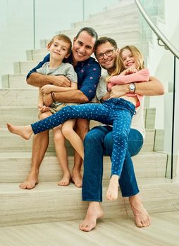 This home is filled with love. Full length portrait of an affectionate family of four on the stairs at home.