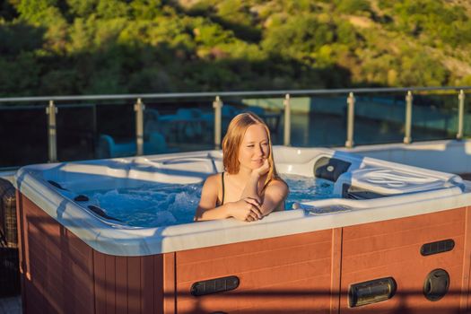Portrait of young carefree happy smiling woman relaxing at hot tub during enjoying happy traveling moment vacation life against the background of green big mountains