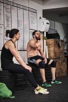Shot of people taking a break from a workout in a gym.