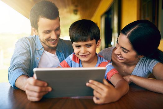 There are some cool learning apps on here. Cropped shot of an affectionate young family using a tablet together at home.