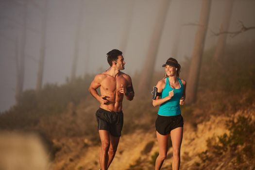 We only give it our all. Shot of an athletic young couple out for a run in the morning.
