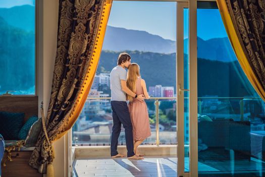 Couple on the balcony against the backdrop of mountains and city, Montenegro. life terrace pretty happiness summer home. Inspiration city romantic hotel