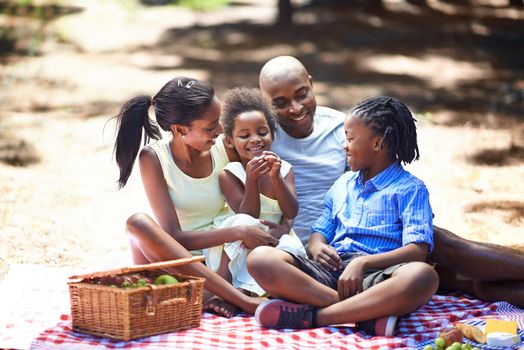 Spending some family time outdoors. Shot of a family enjoying a picnic in the woods.