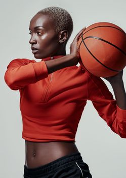 Greatness is the goal. Studio shot of an attractive young woman playing basketball against a grey background.