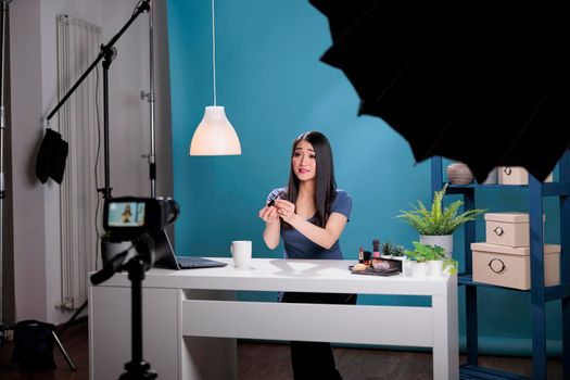 Influencer vlogger recording makeup tutorial presenting lipstick doing review