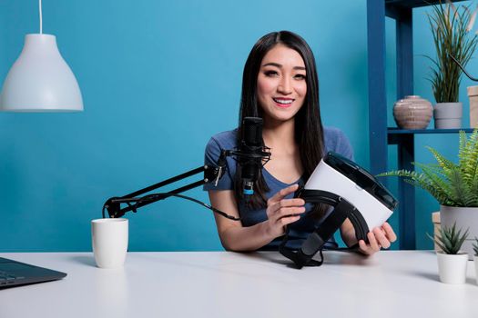 Asian vlogger creator woman holding vitual reality goggles