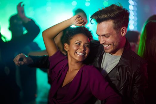 They only have eyes for each other in the club. Shot of a smiling young couple dancing together in a night club.