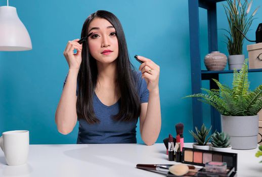 Portrait of asian beauty vlogger doing her makeup in front of camera