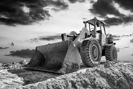A stopping excavator at beautiful sunset. Black and white