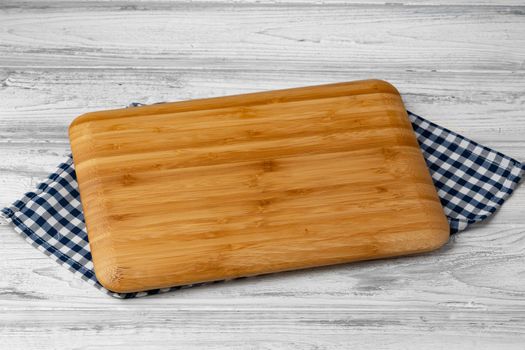 Cutting board with cotton napkin on wooden table