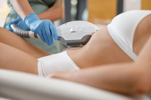 Closeup of young woman getting laser epilation with ipl machine in beauty center. Hair removal