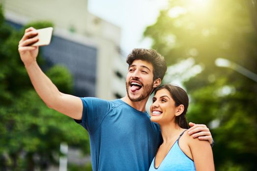 Shot of a sporty young couple taking a selfie together outdoors.