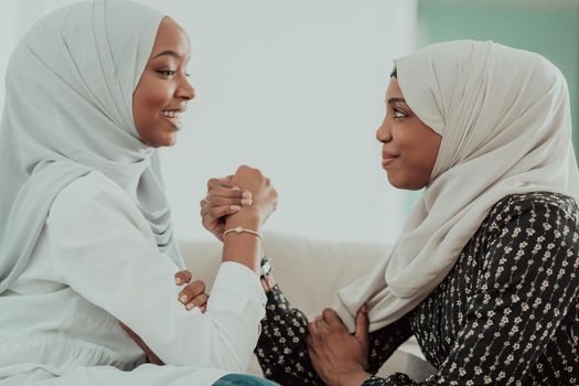 African woman arm wrestling conflict concept, disagreement and confrontation wearing traditional islamic hijab clothes. Selective focus