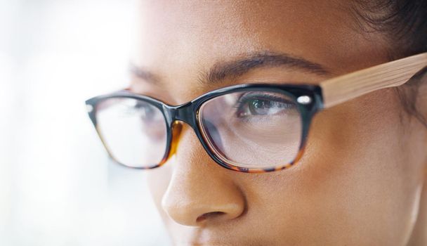 Eyes fully focused on the prize. Closeup shot of an attractive young businesswoman wearing spectacles in a modern office.