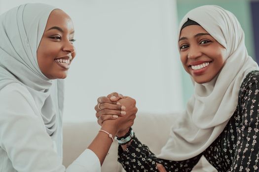 African woman arm wrestling conflict concept, disagreement and confrontation wearing traditional islamic hijab clothes. Selective focus