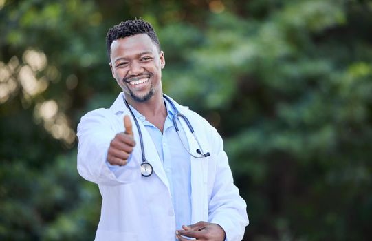 Shot of a young male doctor showing a thumbs up in nature.