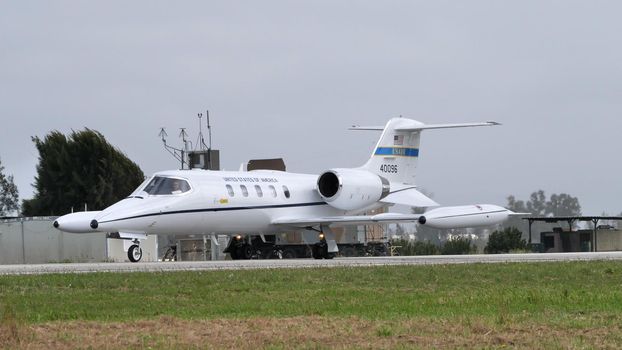 Andravida Greece APRIL, 1, 2022 Modern executive business jet of United Stated air force taxiing on the airport runway. Gates Learjet 35 C-21A of USAF used for passenger and cargo transportation