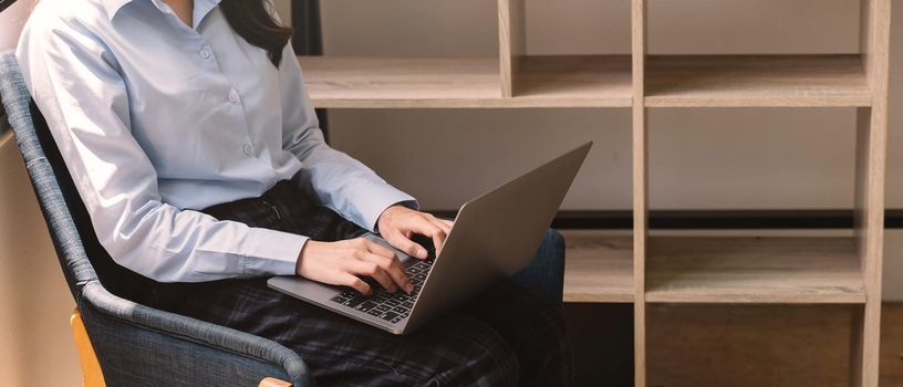 Crop shot of woman using her laptop at home