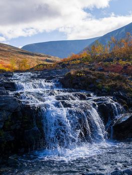 Beautiful mountain waterfall among rocks in polar summer in Khibiny Mountains. Kola Peninsula, Arctic, polar summer
