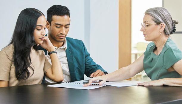 This is what your finances look like. Cropped shot of a young couple going over some paperwork during a meeting with their financial advisor.