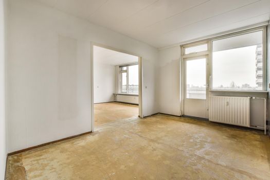 An empty spacious room with large windows