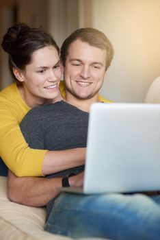Shopping for their new home online. Shot of a loving couple using a laptop together at home.