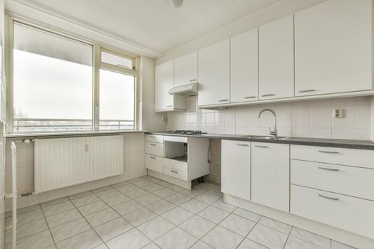 Kitchen with white furniture and tiled floor