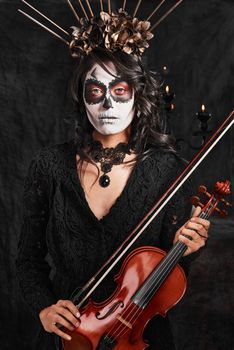 Halloween isnt complete without music. Cropped portrait of an attractive young woman dressed in her Mexican-style halloween costume playing a violin.