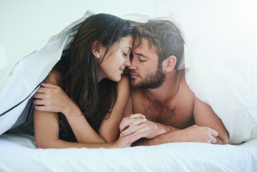 I am more in love with you than ever. Shot of a young couple having an intimate moment under the covers.