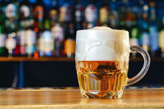 Fresh cold beer in glass on bar background