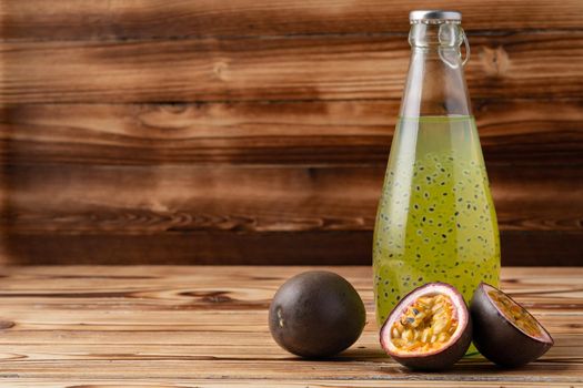 Fruit drink with passion fruit on wooden background, close up