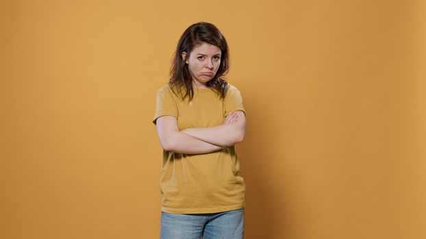 Seriously upset woman with arms crossed feeling sad and disappointed looking grumpy mumbling