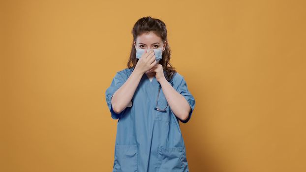 Woman doctor putting on surgical mask for protection against corona virus for covid pandemic awerness