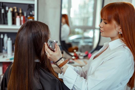 Side view of female makeup artist doing makeup with a brush