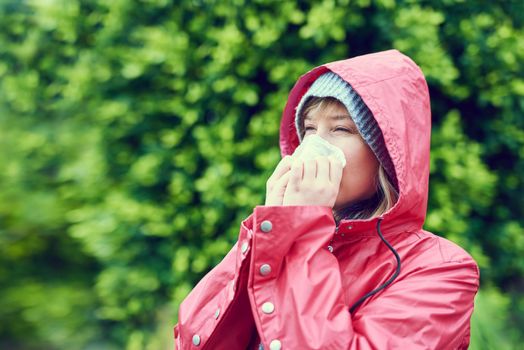 Seasons are changing and so is my health. Cropped shot of a young woman blowing her nose outdoors.